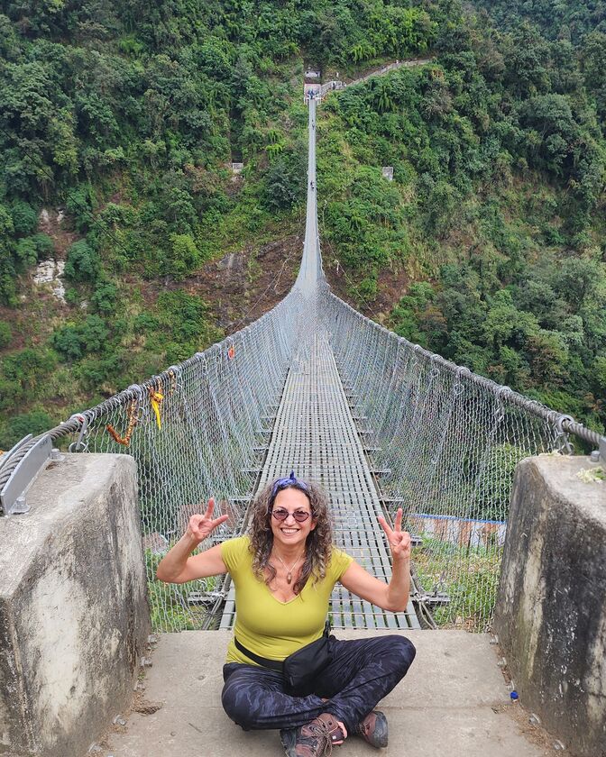 Alaina Schwartz on a suspension bridge while trekking in the Himalayas
